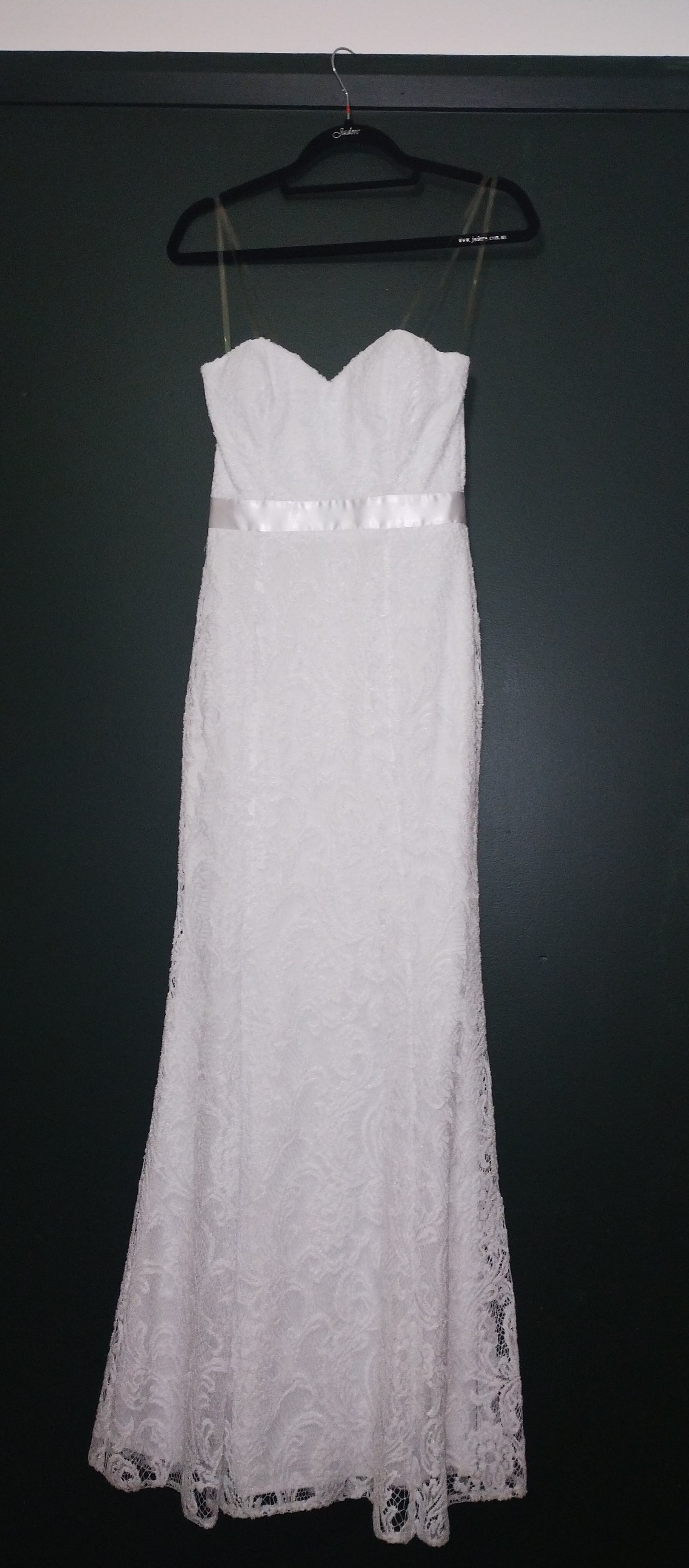 White sheath, sweetheart neckline. Satin ribbon waist detail. Princess line, skirt flares from knee. All lace and lined.