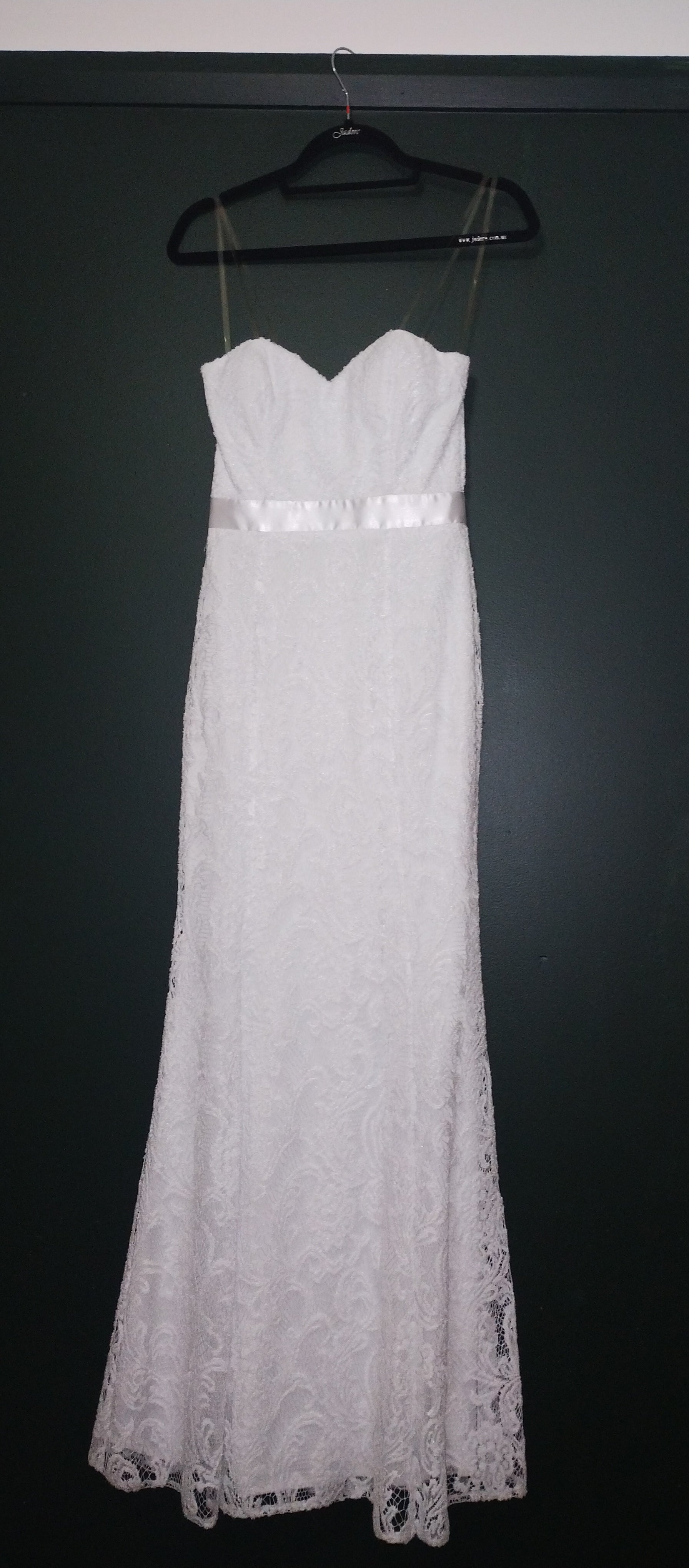 White sheath, sweetheart neckline. Satin ribbon waist detail. Princess line, skirt flares from knee. All lace and lined.